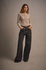 Body negro de microfibra translúcida esmerilada, ajustado al cuerpo, con mangas largas, cuello media polera y frunce central en el delantero. Tiene acceso por entrepierna con broches metálicos.