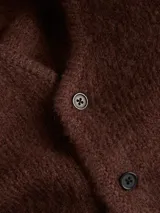 Cardigan de punto color marrón, con cuello en V, cierre frontal de botones y diseño de ajuste holgado con hombros caídos.