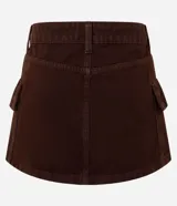 Pollera corta de sarga color negro, con diseño de tiro alto, cierre frontal con botón y cremallera, y bolsillos cargo laterales.