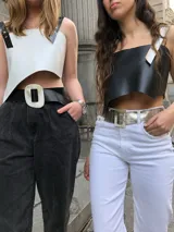 Top corto de ecocuero negro con corte asimétrico y un tirante ancho de ecocuero blanco con textura de piel de cocodrilo. Se ajusta con botones o lazo en la espalda.