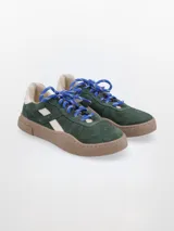 Zapatillas bajas de cuero color marrón con detalles en beige y suela color caramelo.