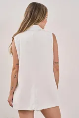 Chaleco sastrero blanco sin mangas, con solapas y cierre frontal con un botón. Posee bolsillos simulados.