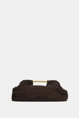 Bolso tipo sobre color marrón, con cuerpo trenzado y asa de mano rígida dorada. Incluye correa bandolera de cadena extraíble y cierre magnético.