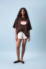 Remera oversize color marrón con estampado frontal que dice "Chill Peel" en rojo y blanco.