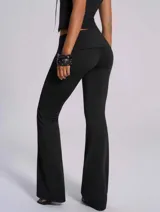 Pantalón negro de tiro bajo con detalle de ojalillos metálicos en la cintura y corte acampanado.