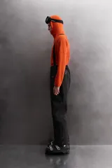 Pantalón deportivo de esquí color negro, confeccionado en tejido técnico impermeable de tres capas con costuras y cremalleras termoselladas. Cuenta con tirantes elásticos regulables, cintura ajustable, bolsillos frontales con cierre, refuerzos en la parte inferior de la pernera y sistema de rescate RECCO integrado.
