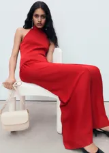 Vestido largo rojo de punto combinado, con cuello halter, sin mangas y diseño evasé con falda fluida y amplia.