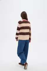 Sweater de tejido de punto con diseño de rayas horizontales en tonos marrones, beige y rosa. Presenta cuello redondo, corte holgado y mangas largas con puños en contraste.