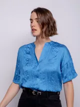 Blusa celeste de manga corta con escote en V y textura plisada.