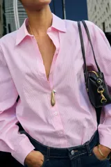 Camisa de algodón con estampado de rayas verticales en color rosado y blanco, cuello solapa y manga larga.