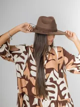 Sombrero de gamuza color tostado, estilo cowboy, con ala ancha y detalle de trenzado en la base de la copa.