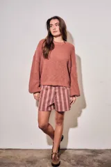 Sweater de tejido bouclé texturado color beige, con cuello redondo y mangas largas holgadas de corte amplio.