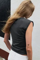 Camiseta sin mangas gris con efecto lavado, de corte regular y cuello redondo decorado con aplicaciones de pedrería a contraste.