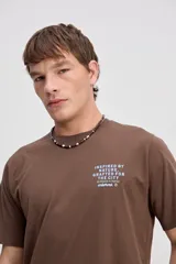 Remera de algodón marrón de manga corta, con cuello redondo y detalle estampado pequeño en el pecho.