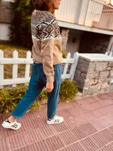 Sweater tostado tejido en lana con textura suave. Diseño con motivos geométricos en blanco y negro en la parte superior y bloque de color beige en la parte inferior.