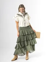 Falda larga color verde militar, confeccionada en algodón, con diseño de múltiples volados escalonados y cintura elastizada.