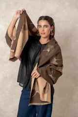 Pashmina reversible de textura suave y caída fluida, con diseño estampado de hojas de ginkgo biloba. Presenta un lado con fondo oscuro y otro con fondo claro, finalizando en ambos extremos con flecos cortos deshilachados.