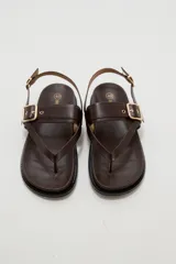 Sandalias negras de eco cuero estilo chunky, con diseño de tiras cruzadas y hebilla metálica dorada en la parte superior. Cuenta con tira ajustable en el talón.