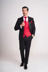 Ambo de ceremonia compuesto por saco negro con solapas de satén, chaleco rojo satinado, camisa blanca, corbatín rojo y pantalón de vestir negro a juego.