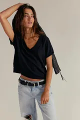 Remera de jersey suave color negro, de calce relajado, corte recto y largo corto, con escote en V y mangas cortas caídas con puño fijado.