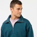 Buzo de algodón color azul petróleo, con cuello tipo camionero y cierre frontal parcial con cremallera. Presenta puños y cintura acanalados.