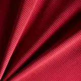 Remera deportiva de manga corta color bordo, con cuello redondo y el logotipo reflectante de la marca en el pecho.