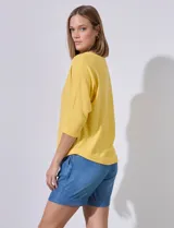 Buzo amarillo de algodón marca Ninety, con escote en V y mangas 3/4. Tejido fino con pespuntes verticales en el centro del frente y la espalda.