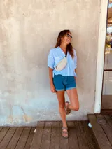 Riñonera de cuero color marrón claro con cierre superior y correa ajustable.