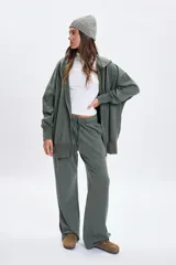 Pantalon deportivo de corte ancho y tiro alto, con efecto lavado en color verde. Presenta cintura elástica con cordón ajustable y aberturas laterales en el ruedo.