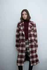 Chaqueta larga de corte sastre con estampado de cuadros en tonos bordó y beige. Presenta solapas clásicas, cierre frontal con botones y bolsillos laterales con solapa.