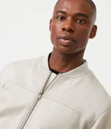 Chaqueta bomber azul marino lisa, con cierre frontal, cuello redondo y bolsillos laterales.