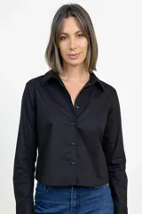 Camisa de corte clásico y diseño cropped, color negro, con cuello camisero, cierre frontal de botones y mangas largas con puños abotonados.