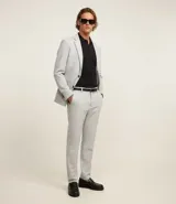 Pantalón de sastrería corte skinny, color gris claro, con trabillas en la cintura, cierre de botón y cremallera, y bolsillos laterales. Confeccionado con tecnología performance que ofrece secado rápido y resistencia a las arrugas.