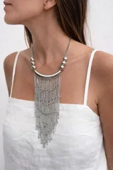 Collar largo de estilo cascada en color plateado, compuesto por una base de media luna metálica de la cual descienden múltiples cadenas finas con pequeñas esferas decorativas, rematado con esferas metálicas en los laterales superiores.