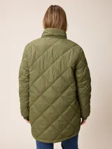 Campera larga acolchada con diseño de rombos, cierre frontal completo y cuello alto. Presenta puños elásticos y un pequeño logo aplicado en el pecho.