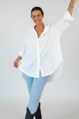 Camisa de algodón de corte oversize y calce relajado, con cuello camisero clásico, mangas largas con puños y ruedo irregular más largo en la parte posterior.