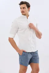 Short de baño color celeste con bordado de pequeñas palmeras, cintura elastizada y bolsillos laterales.