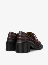 Mocasín de piel vacuna color bordó con detalles de costuras en rojo, cordones decorativos y suela XL EXTRALIGHT de EVA negra con tacón de 7 cm.