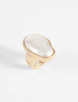 Anillo dorado con forma orgánica irregular y piedra plateada.