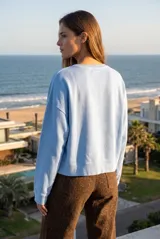 Buzo lila oversize confeccionado en 100% algodón, con cuello redondo, mangas largas y puños y dobladillo acanalados. Presenta un pequeño detalle bordado en el bajo.