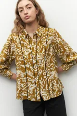 Camisa color ocre con estampado floral blanco, de manga larga, con botones de nácar y bordados a contratono.