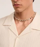 Collar corto de perlas artificiales blancas alternadas con dijes de estrellas plateadas.