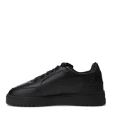 Championes urbanos Puma modelo Shuffle Downtown, color blanco con detalles en negro en la parte trasera y logo dorado en el lateral. Presentan suela de plataforma y cierre con cordones.