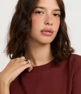 Remera de algodón color marrón óxido, de corte oversized, cuello redondo y manga corta.