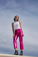 Pantalón capri semi oxford de tiro alto, color fucsia metalizado, confeccionado en bengalina engomada metálica. Presenta bolsillos delanteros y traseros, botón metálico níquel y corte a la altura de la rodilla.