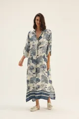 Vestido camisero largo de seda color blanco con estampado de serpientes, árboles y animales en azul.