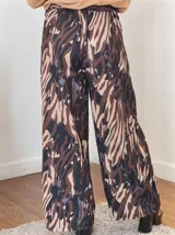 Pantalón palazzo de crepe con spandex, estampado con diseño abstracto en tonos marrón, beige, negro y azul. Cintura elastizada con lazo.