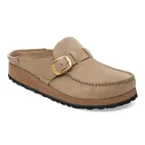 Zuecos tipo mocasín de gamuza color marrón tabaco, con detalle de hebilla metálica dorada ajustable en el empeine. Presentan una suela de corcho característica y base de goma negra antideslizante.