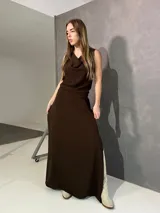 Falda larga marrón, de corte evasé, confeccionada en viscosa y elastano con pretina frontal y elástico trasero.