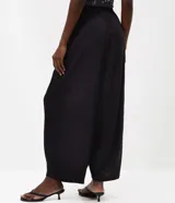 Pantalón de viscosa color negro, con diseño amplio estilo aladín, caída liviana y cintura elástica.